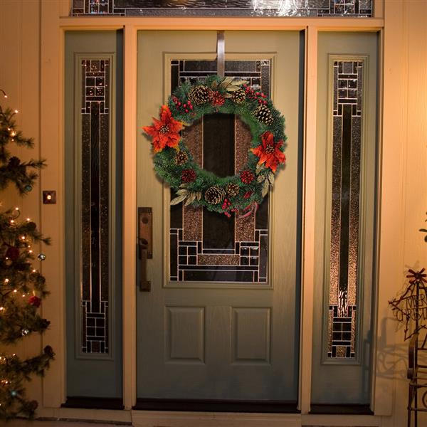 Christmas Wreath Decorated With Red Flowers And Pine Nuts